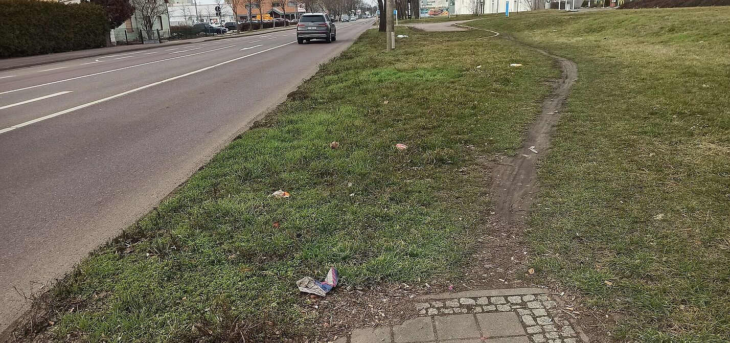 Ein Rad- und Gehweg endet abrupt, es bildet sich ein Trampelpfad in der anschließenden Grünfläche. 